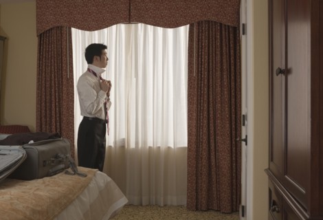 Chinese businessman undressing in hotel room