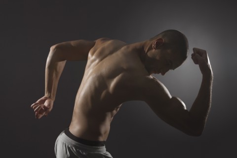 Mixed race athlete flexing biceps
