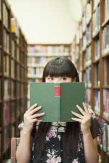 Asian woman reading book in library