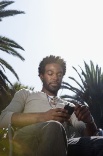 Black man listening to mp3 player outdoors