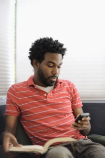 Black man text messaging on cell phone