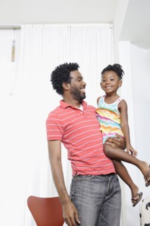 Black father holding daughter