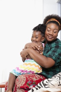 African American mother holding daughter on lap