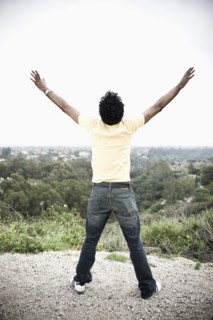 African American man with arms outstretched in remote area