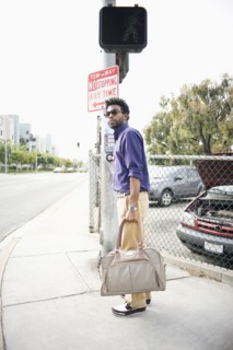African American man carrying bag on sidewalk