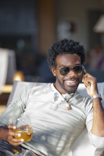 Black man talking on cell phone and drinking