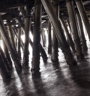Wooden pillars of boardwalk in waves
