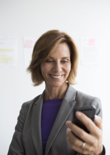 Caucasian businesswoman using cell phone in office