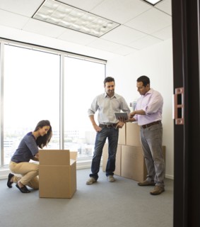 Business people unpacking in new office