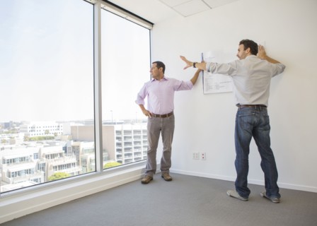 Hispanic businessmen examining blueprints in office