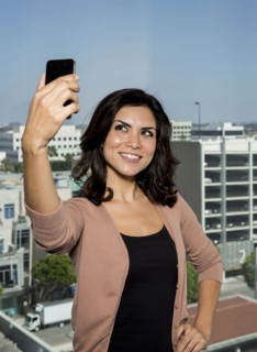 Mixed race businesswoman taking cell phone picture