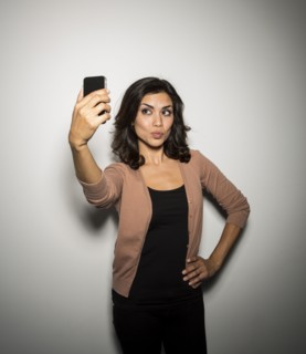 Mixed race businesswoman taking cell phone picture