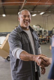Workers shaking hands in warehouse
