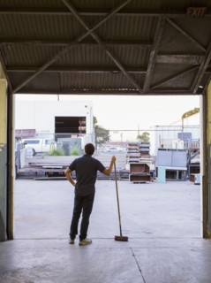 Worker holding broom in warehouse