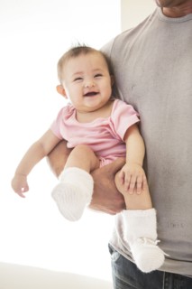 Father carrying laughing baby girl