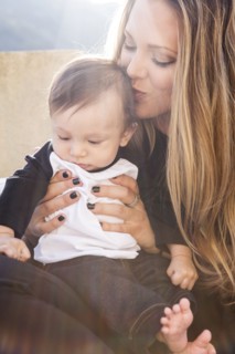 Mother kissing baby boy outdoors