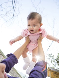 Mother playing with baby girl outdoors