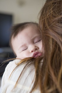 Mother holding sleeping baby girl