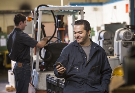 Worker using cell phone in warehouse