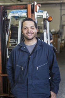 Hispanic worker smiling in warehouse
