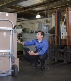 Caucasian businessman examining boxes in warehouse