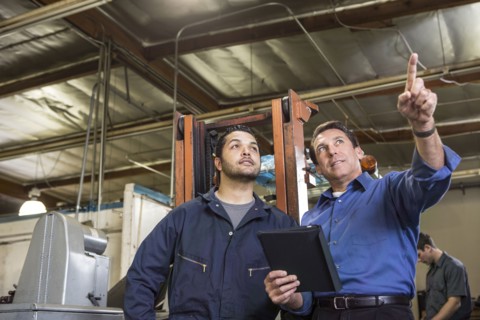 Worker and businessman talking in warehouse