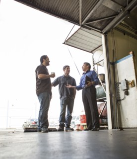Manager and workers talking at warehouse loading dock