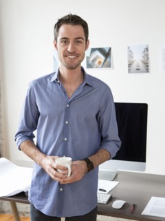 Caucasian architect drinking coffee in office