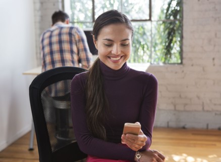 Mixed race architect using cell phone in office