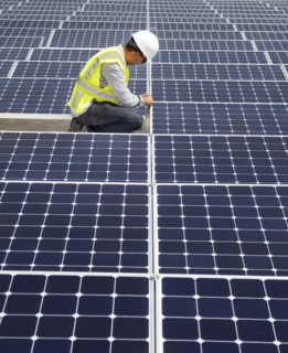 Asian technician working on solar panels