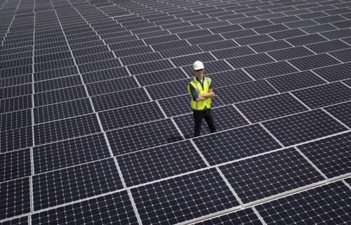 Caucasian technician smiling on solar panels