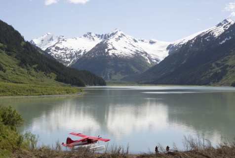 Seaplane docked in still lake in mountain landscape