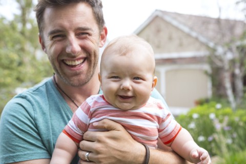 Caucasian father holding baby outdoors