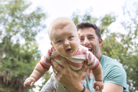 Caucasian father playing with baby outdoors