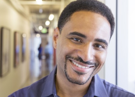 Black businessman smiling in office hallway