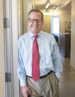 Caucasian businessman smiling in office hallway