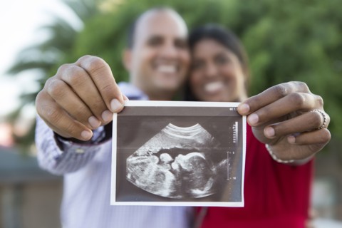 Happy couple holding sonogram