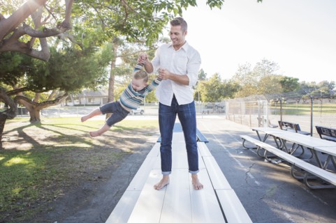 Caucasian father and son playing on picnic table