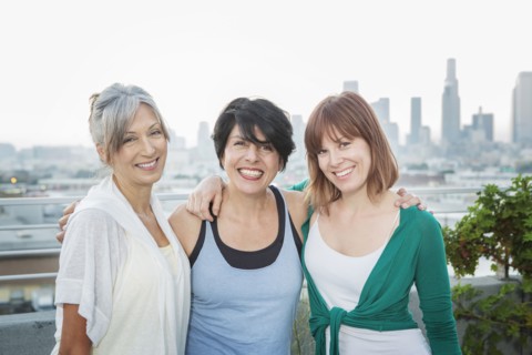 Women smiling together on urban rooftop
