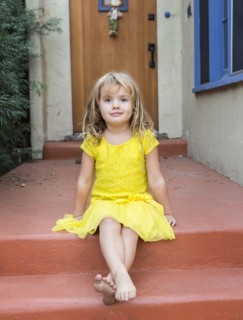 Caucasian girl sitting on front stoop
