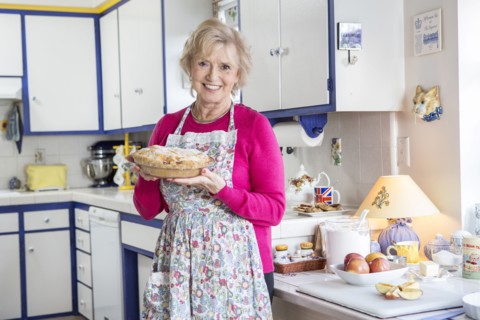 Older Caucasian woman baking pie in kitchen