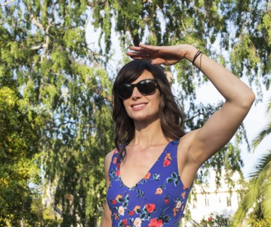 Hispanic woman shielding her eyes from sun
