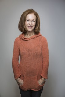 Caucasian woman smiling with hands in pockets