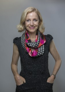 Smiling Caucasian woman standing with hands in pockets