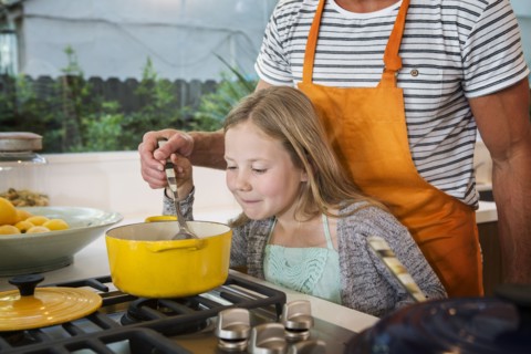 Caucasian father and daughter cooking in kitchen