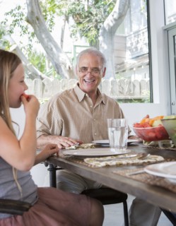 Caucasian multi-generation family eating at table