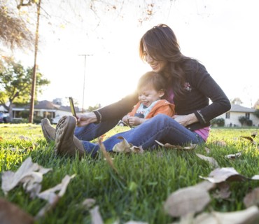 Hispanic mother taking selfie with son in park
