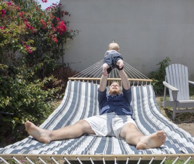 Caucasian father and son playing on hammock