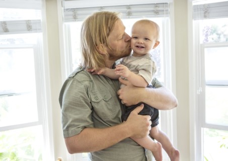 Caucasian father kissing son indoors