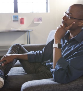 Mixed race businessman thinking in office